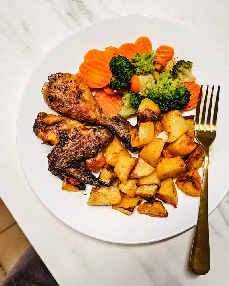 Frango assado com limão, batatas e legumes