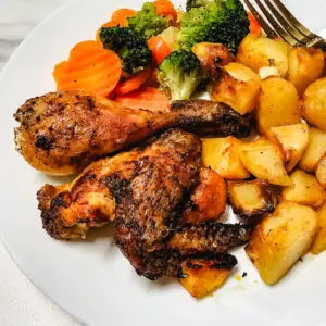 Frango assado com limão, batatas e legumes