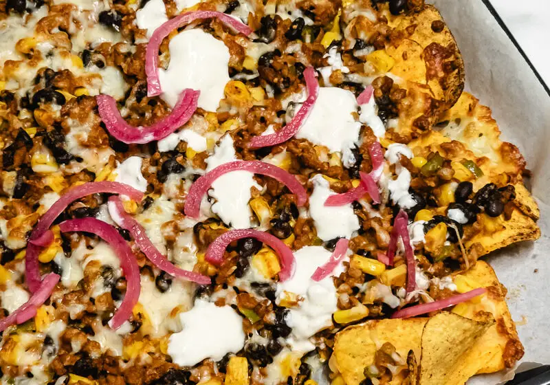 Nachos no forno: Tabuleiro acabado de sair do forno, com queijo derretido e as tortilhas crocantes.